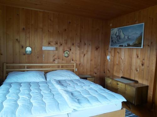 a bedroom with a large bed in a wooden wall at Zimmerhäusl in Schlitters