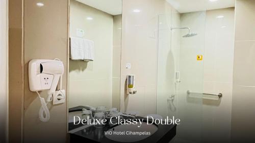 a bathroom with a shower and a phone on the wall at Vio Cihampelas in Bandung