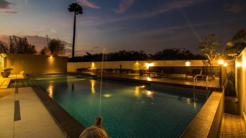 a swimming pool at night with lights on at GTV Hotel in Cikarang