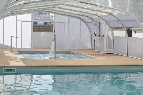 a swimming pool with an arch over the water at Camping Domaine du Morbihan in Ambon