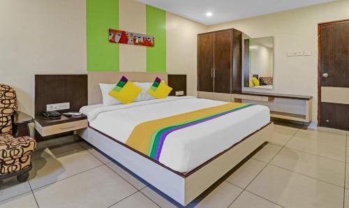 a bedroom with a rainbow bed and a chair at Hotel G Square in Vijayawāda