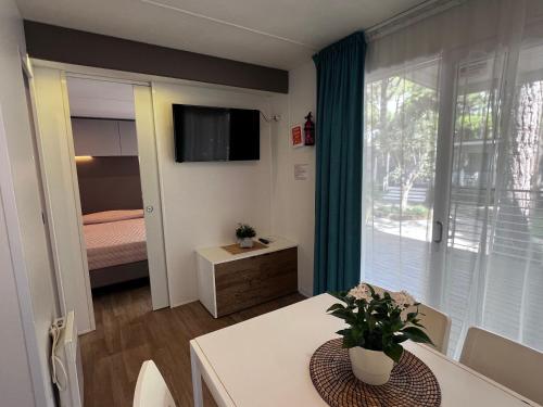 a room with a dining table and a bedroom at Dune Prestige & Chalets in Bibione