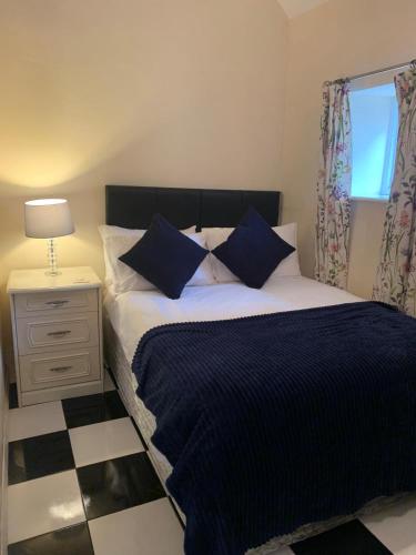 a bedroom with a bed with blue sheets and a window at Lodge 1, The Grange in Wick