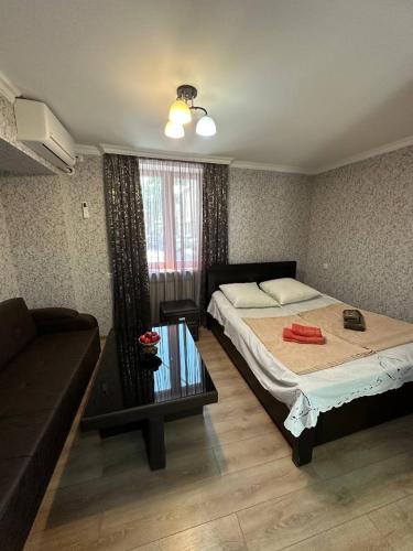 a small bedroom with a bed and a couch at Guest House - Avlabari in Tbilisi City