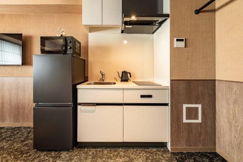 a kitchen with a refrigerator and a sink at Apartment Hotel 11 Gion in Kyoto