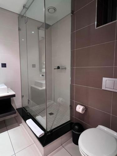 a bathroom with a shower with a toilet and a sink at The Residences at Crystal Towers in Cape Town