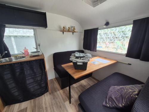 a small kitchen with a table and a desk in a caravan at Carabois in Esson