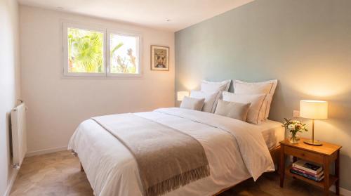 a bedroom with a large white bed with a window at Les sapins verts - vue haras in Saint Lo