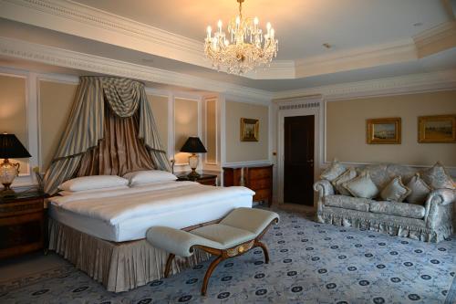 a bedroom with a bed and a couch and a chandelier at InterContinental - Kyiv by IHG in Kyiv