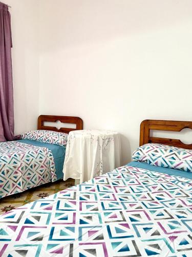 two twin beds in a room withthritisthritisthritisthritisthritisthritisthritisthritisthritis at Relax in Oued Laou in Oued Laou