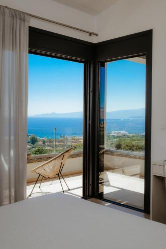 a bedroom with a bed and a view of the ocean at Apollonia Elounda View Villa in Elounda