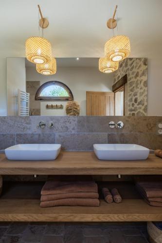 a bathroom with two sinks and two mirrors at Les gîtes de la Grange de Léonie - jacuzzis privatifs et Piscine in Vierzon