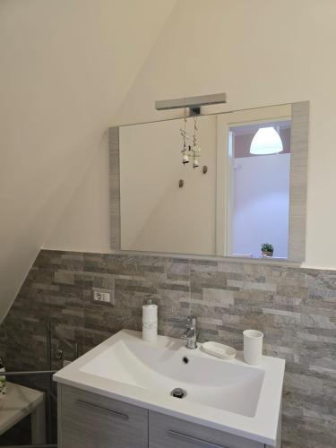 a bathroom with a white sink and a mirror at Da zio Totò in Scilla