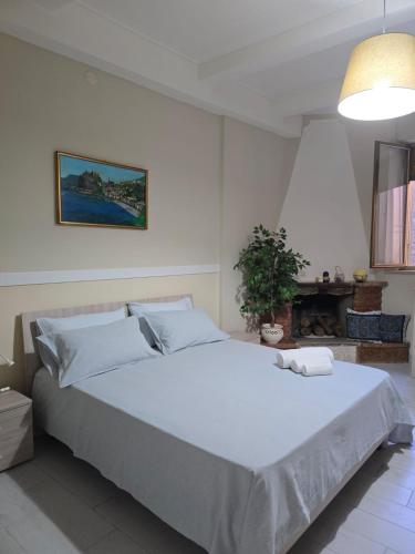 a bedroom with a large white bed in a room at Da zio Totò in Scilla