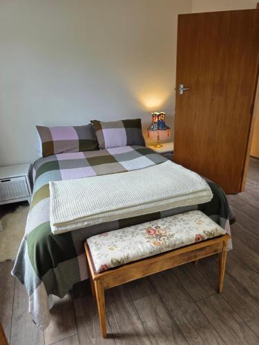 a bedroom with a bed with a bench next to it at Annie's in Methven