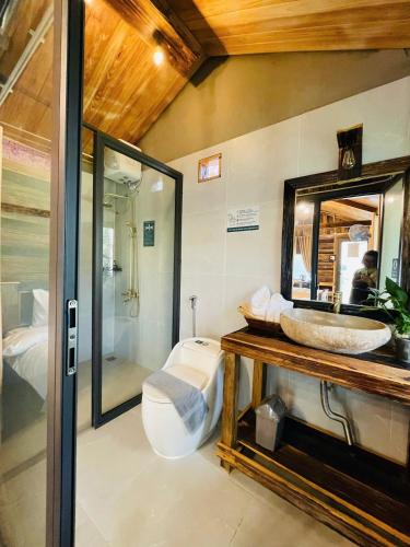 a bathroom with a sink and a toilet and a mirror at Lam Ecolodge Mu Cang Chai in Nam Khat