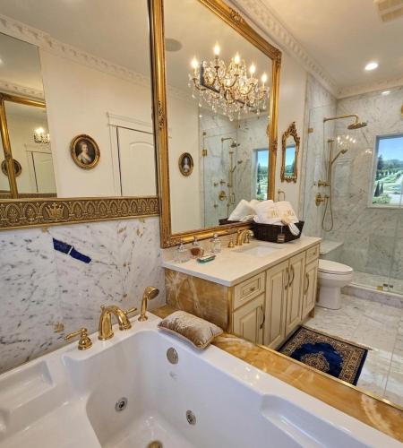 a bathroom with a tub and a large mirror at Royal Boutique Hotel, Greater Vancouver in Surrey