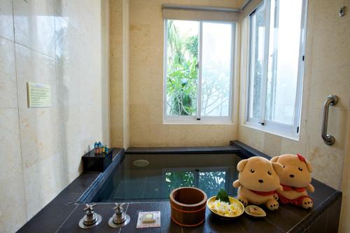 twee teddyberen zitten op een wastafel in een badkamer bij Papago International Resort in Chishang