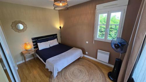 a bedroom with a bed and a fan and a window at Appartement, Calme, Cosy et Balcon in Châteauroux