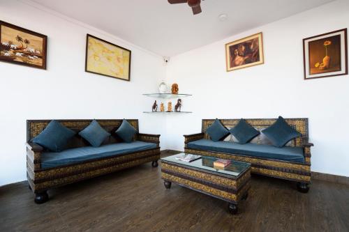 a living room with two couches and a table at Mariaariose - "Melody of the Sea" in Bogmolo