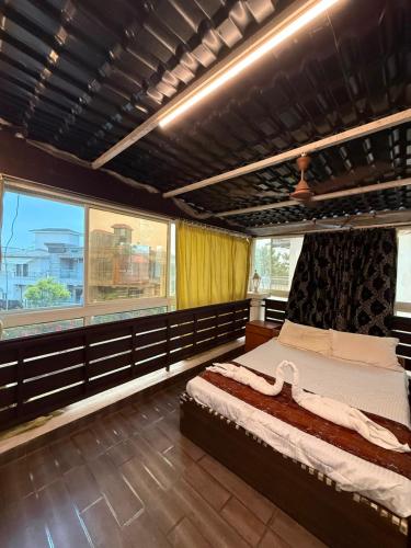 a bedroom with a large bed and a large window at Chikku 4 bhk villa in Lonavala
