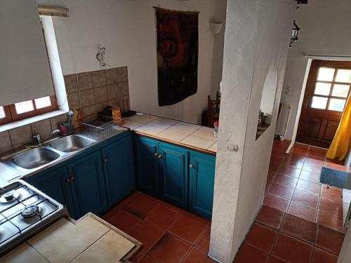 a kitchen with blue cabinets and a sink at Le gîte panda saint-maymes in Trigance