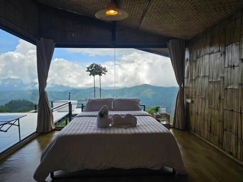 a bedroom with a large bed with a large window at Mon Ngo misty haven B4 in Ban Mae Ta Man