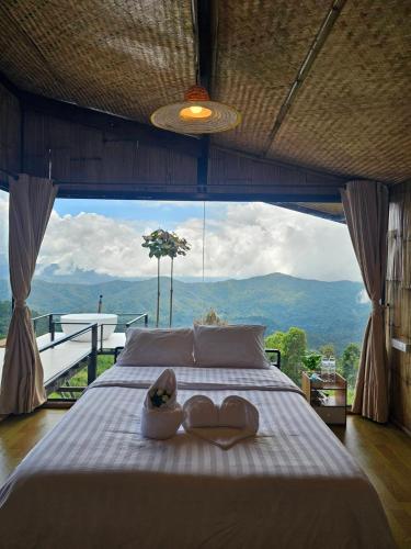 a bedroom with a bed with a large window at Mon Ngo misty haven B4 in Ban Mae Ta Man