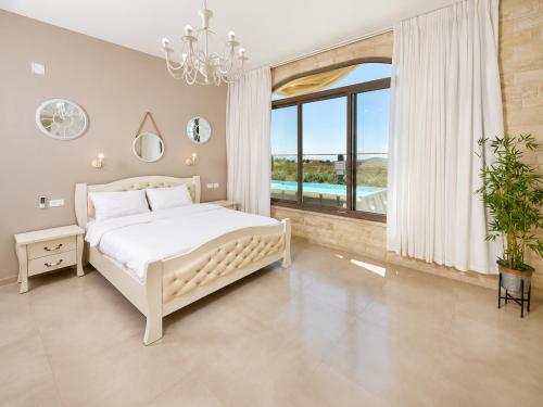 a bedroom with a white bed and a large window at וילה לוזון - וילה מדהימה עם בריכה פרטית מחוממת ומקורה בכרם בן זמרה in Kerem Ben Zimra