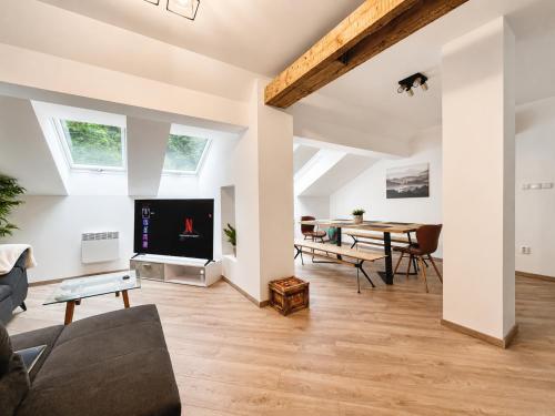a living room with a couch and a table at The Mountain Sky Apartment - prostorný loft 212 m2 s lesem za okny vhodný pro rodiny s dětmi, terasa, dětský koutek, parkování zdarma in Jeseník