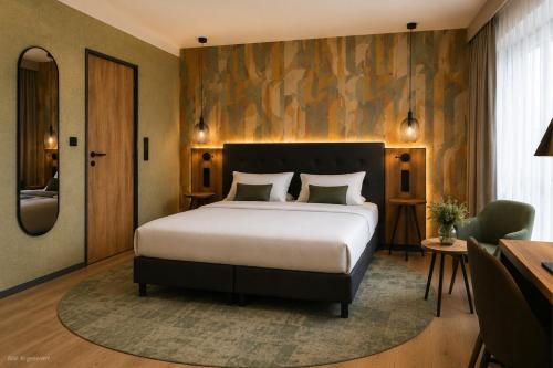 a bedroom with a large bed and a desk at RiKu Hotel Giengen in Giengen an der Brenz