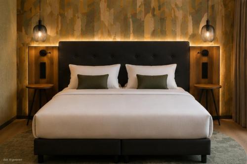 a bedroom with a large bed with two night stands at RiKu Hotel Giengen in Giengen an der Brenz