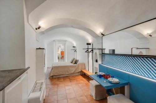 a room with a blue table and a bed at Starhost - RICORDO DEL CAPITANO, Atrani hidden gem Walking distance from Amalfi & Beach in Atrani