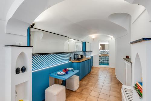 a kitchen with blue cabinets and a blue table at Starhost - RICORDO DEL CAPITANO, Atrani hidden gem Walking distance from Amalfi & Beach in Atrani
