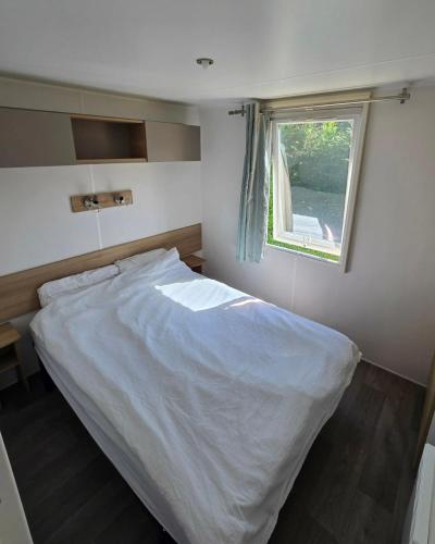 a bedroom with a white bed with a window at Parc St Vincent in La Celle-sous-Gouzon