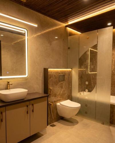 a bathroom with a toilet and a sink and a shower at Hotel Atlantiis Suites By Signature StayZ Rathyatra Near Vishwanath Temple in Varanasi