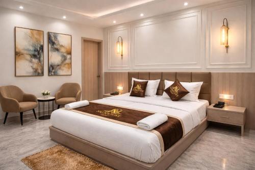 a bedroom with a large bed and two chairs at Hotel Atlantiis Suites By Signature StayZ Rathyatra Near Vishwanath Temple in Varanasi