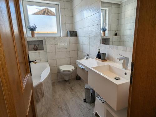 a bathroom with a sink and a toilet and a window at Forest Lodge - perfekt für Familien und Freunde in Bayerisch Eisenstein