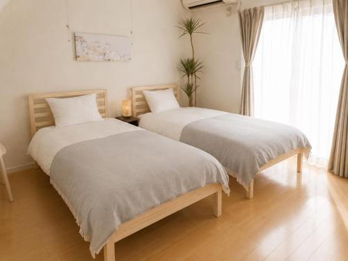two beds sitting next to each other in a room at Dori Dori House Ebisu in Tokyo