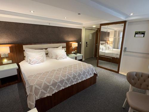 ein Hotelzimmer mit einem großen Bett und einem Spiegel in der Unterkunft Endglory Hotel in Çorlu