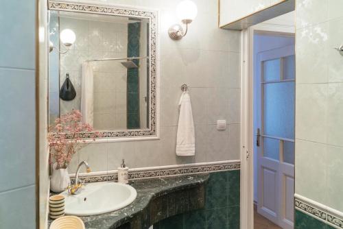ein Bad mit einem Waschbecken und einem Spiegel in der Unterkunft Guest house Maison 21 in Plowdiw