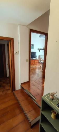 a living room with a mirror and a room with a table at Zorel House in Siena