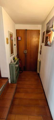 a hallway with a wooden door and a wooden floor at Zorel House in Siena