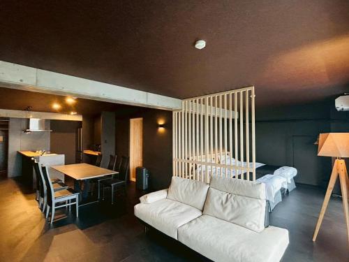 a living room with a white couch and a table at Casa Luce Sasebo Hotel in Sasebo