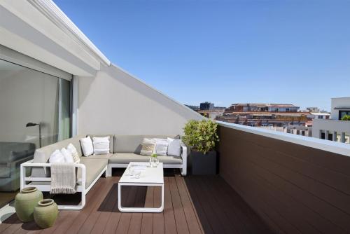a balcony with a couch and a table on a roof at NH Sants Barcelona in Barcelona