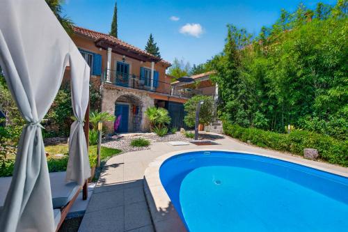 a swimming pool in front of a house at Villa Balic in Gruda