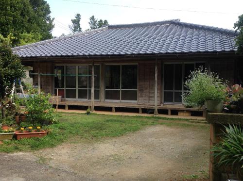 a house with a porch and some plants at Huuran in Nakijin