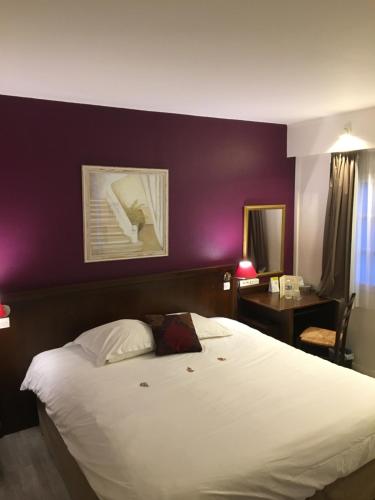 a bedroom with a white bed with a purple wall at Logis Hôtel Les Nymphéas in Chaufour-lès-Bonnières