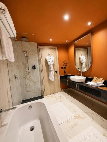 a large bathroom with a tub and a sink at M Hotels at Porto Marina in El Alamein