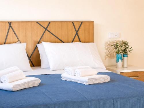 a bed with three towels on top of it at The Queen Oak - nature relais in Santa Marina
